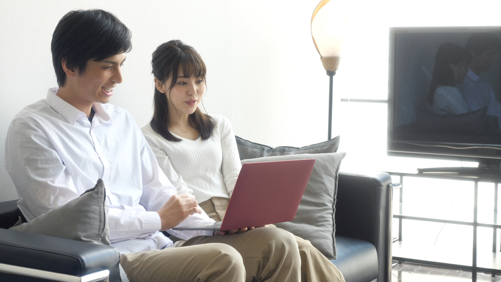 パソコンを見ながら話し合う夫婦