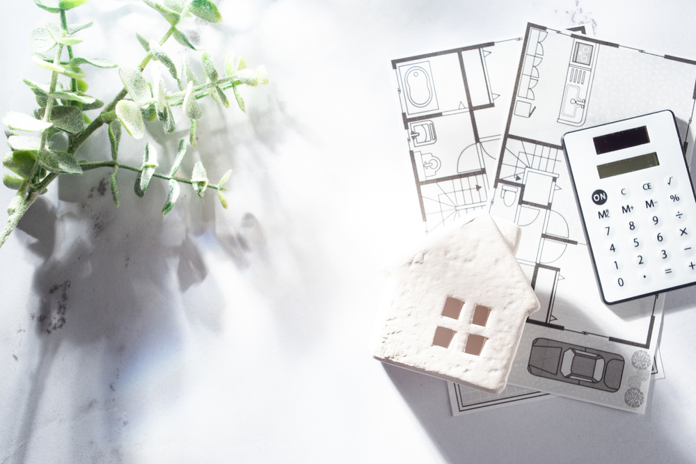 家の模型と間取り図と電卓