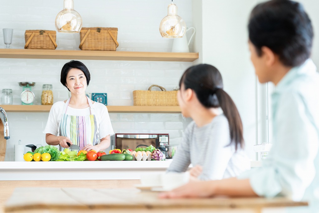 アイランドキッチンで料理をする女性