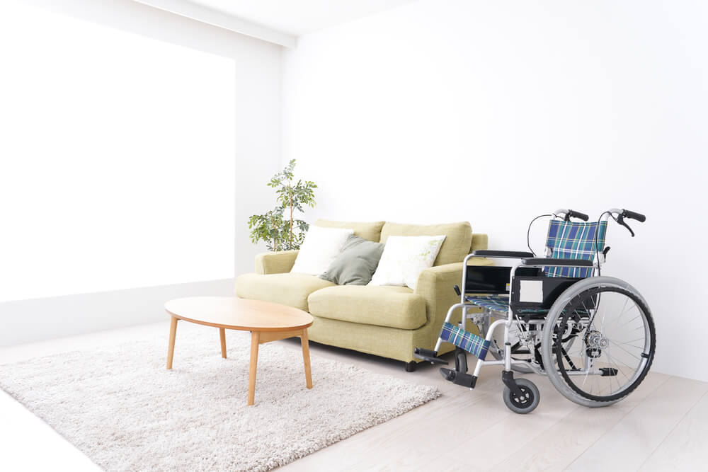 リビングにある車イスと机とソファー