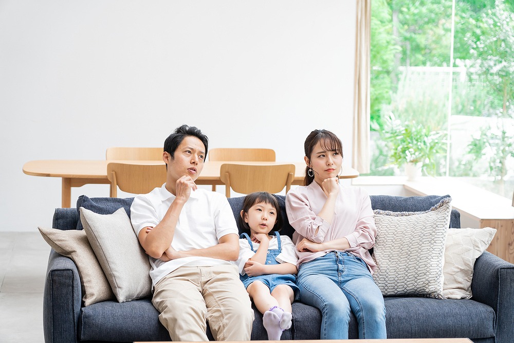 ソファに座り悩む家族