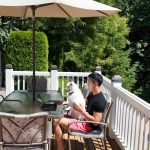 犬と一緒にアウトドアリビングでくつろぐ人