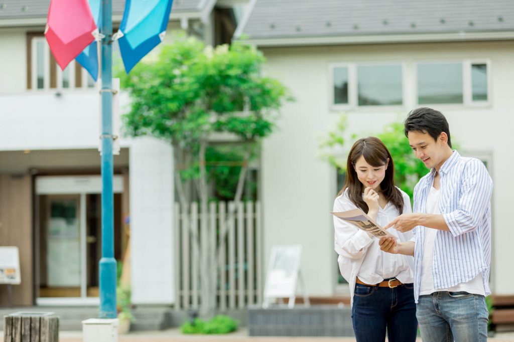 展示場でパンフレットを眺める夫婦